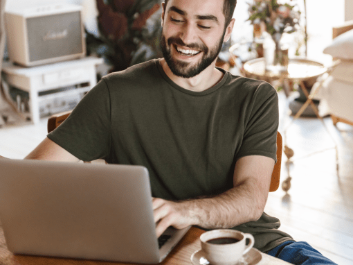 A smiling man working from home on his laptop, feeling accomplished as AI helps him organize and manage his writing projects.
