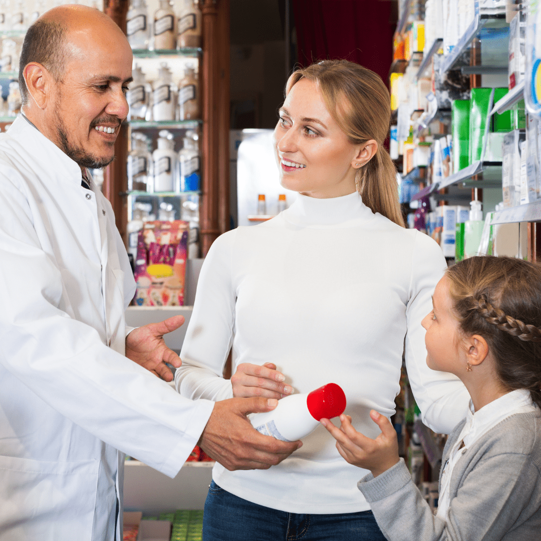 A friendly pharmacist assisting a family at a counter.