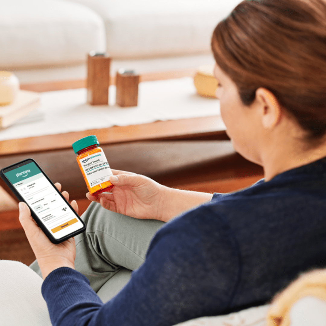 A woman looking at her medication and checking her phone for prescription updates.