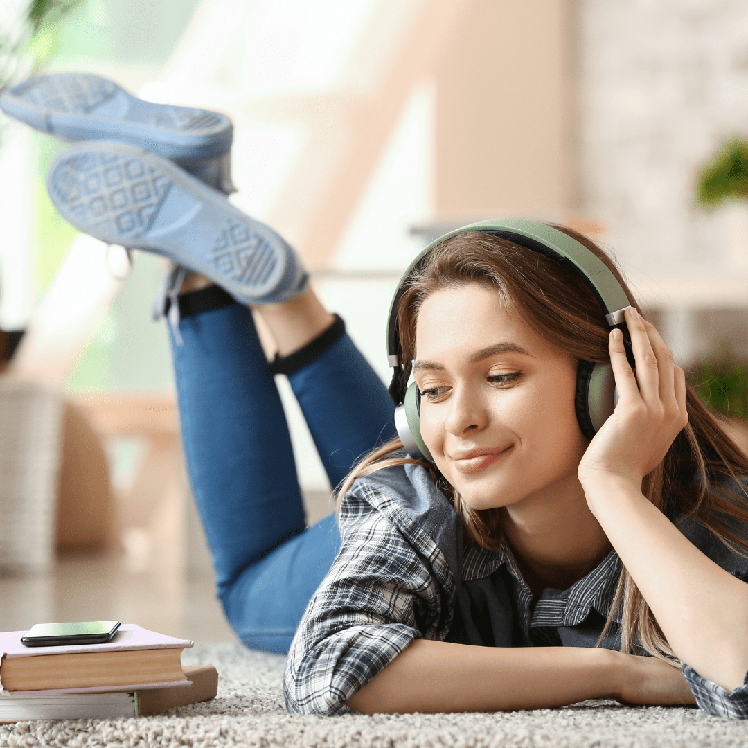 Young lady listening to audiobook with headphones
