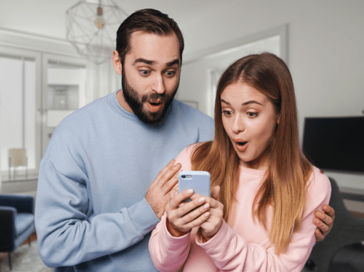 An excited young couple reacting to what they see on a phone