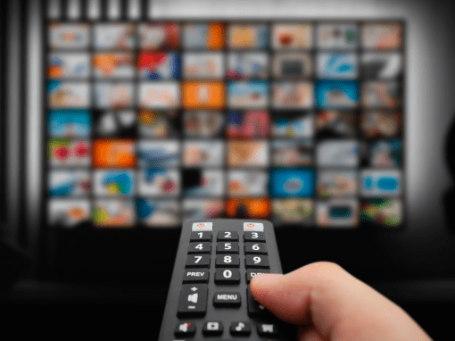 Someone holding a tv controller and pointing it at a tv.