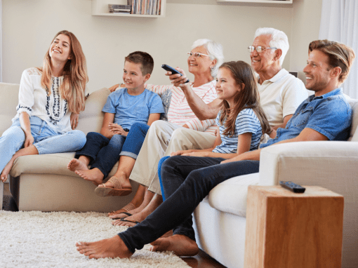 Family of multiple generations watching a patriotic movie together at home, symbolizing shared remembrance and appreciation.