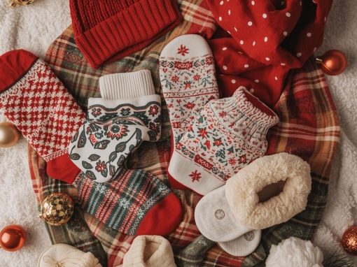 Flat lay of Christmas socks, cozy slippers, and winter accessories arranged for holiday gifting