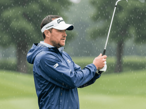 Golfer playing in light rain while wearing a lightweight golf jacket that provides warmth and weather protection during play