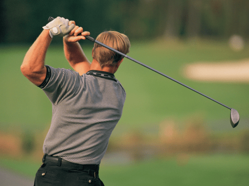 Golfer finishing a driver swing while wearing lightweight, breathable golf apparel that allows unrestricted movement on a sunny course