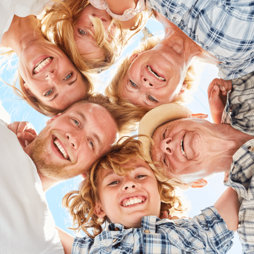 A Happy Family Family all smiling, joined in a circle, and looking down for a photo.